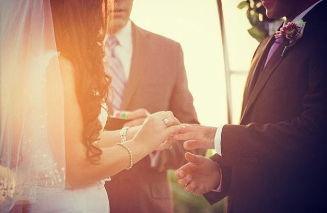 Bride and Groom Holding Hands Before an Officiant