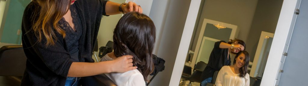 Woman Braiding Brown Hair in a Salon